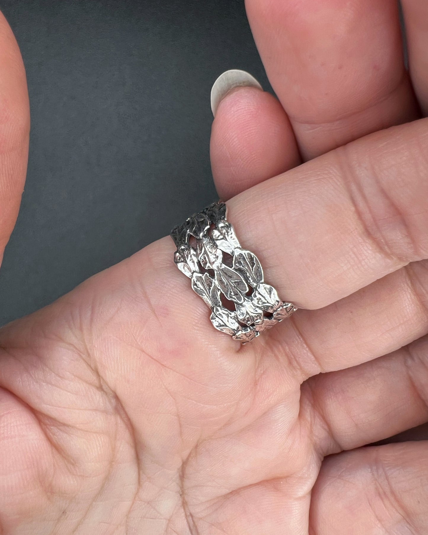 Woman's hands wearing oxidized sterling silver triple cedar ring with three bold bands, cast from real cedar.