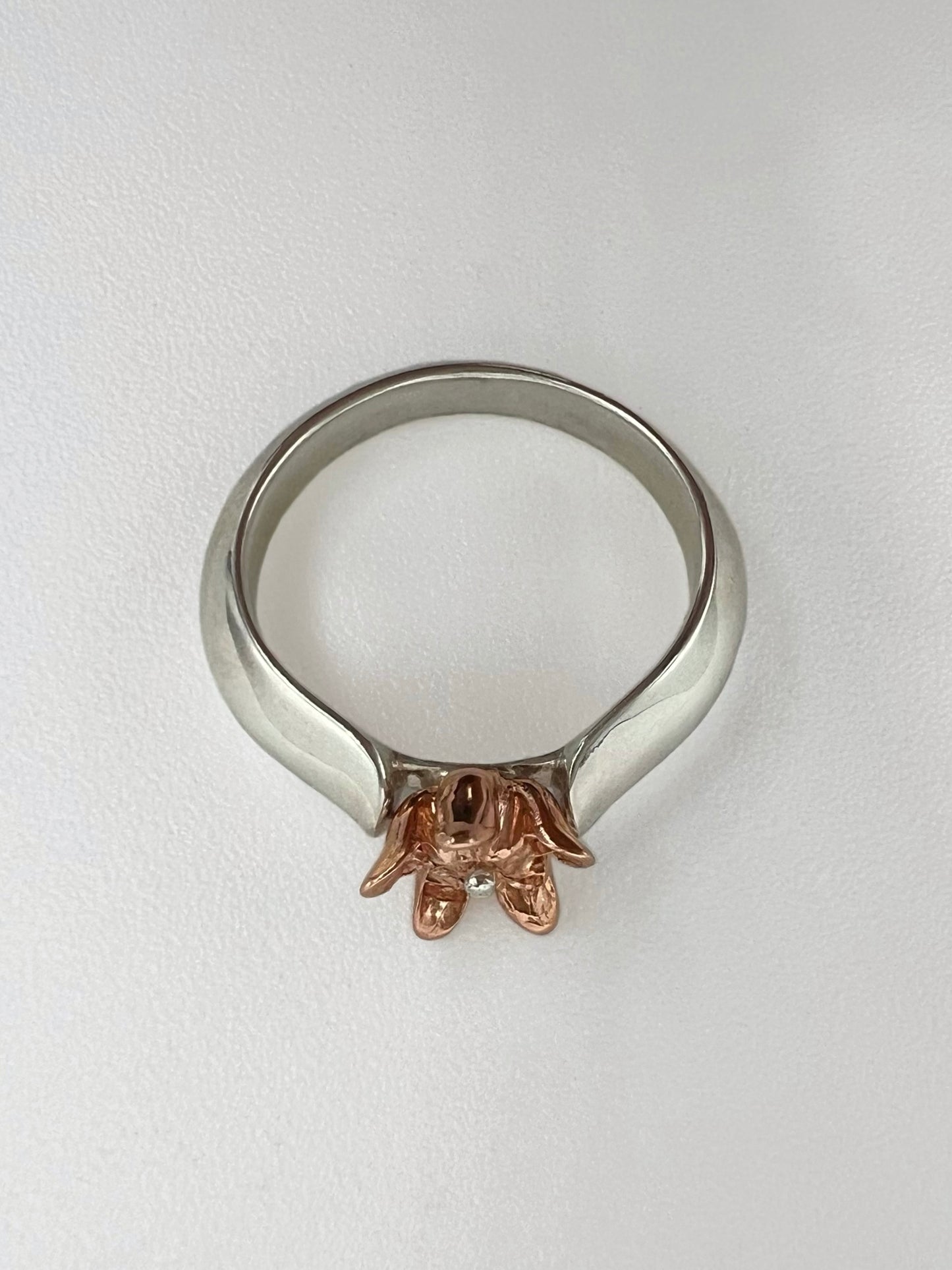 Ring with sterling silver band shaped like a leaf with a pink gold milkweed flower rising from between the "leaves"