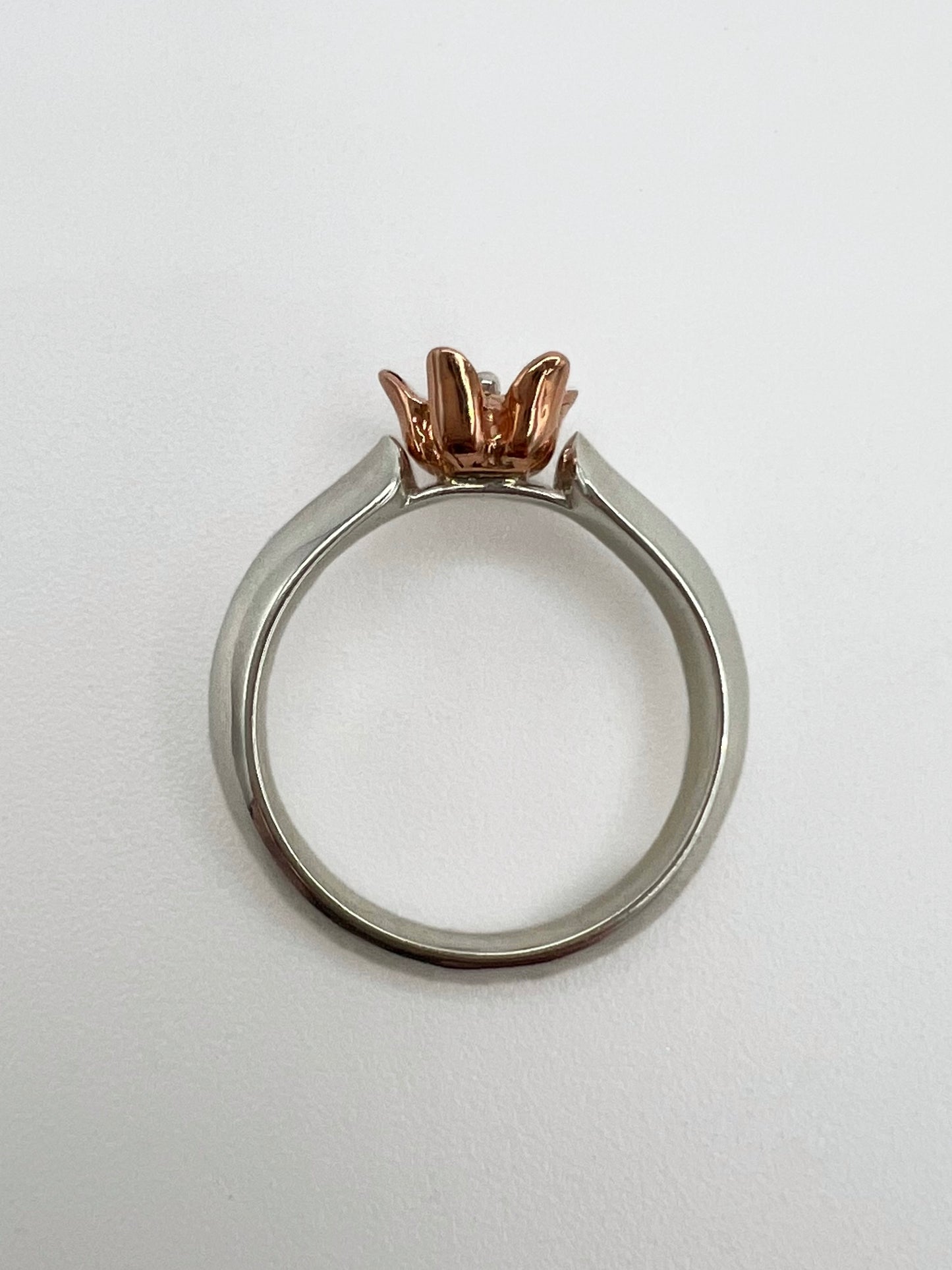Ring with sterling silver band shaped like a leaf with a pink gold milkweed flower rising from between the "leaves"