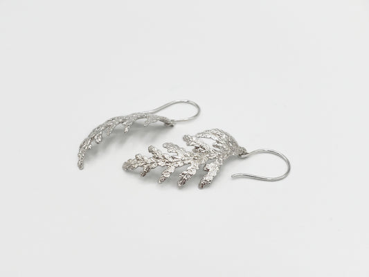 Sterling silver cedar dangle earrings shown from a sideways angle.