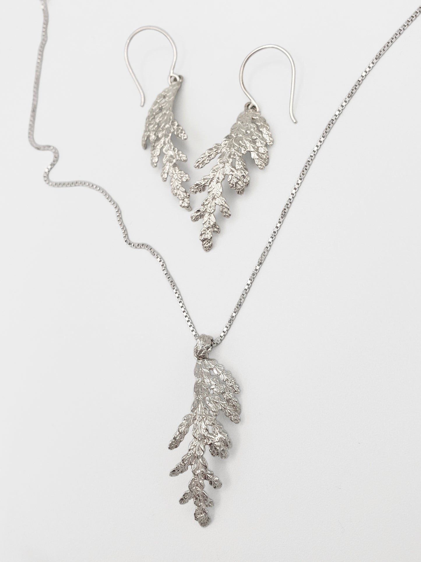 Sterling silver matching set of jewellery, including cedar pendant and dangle earrings.