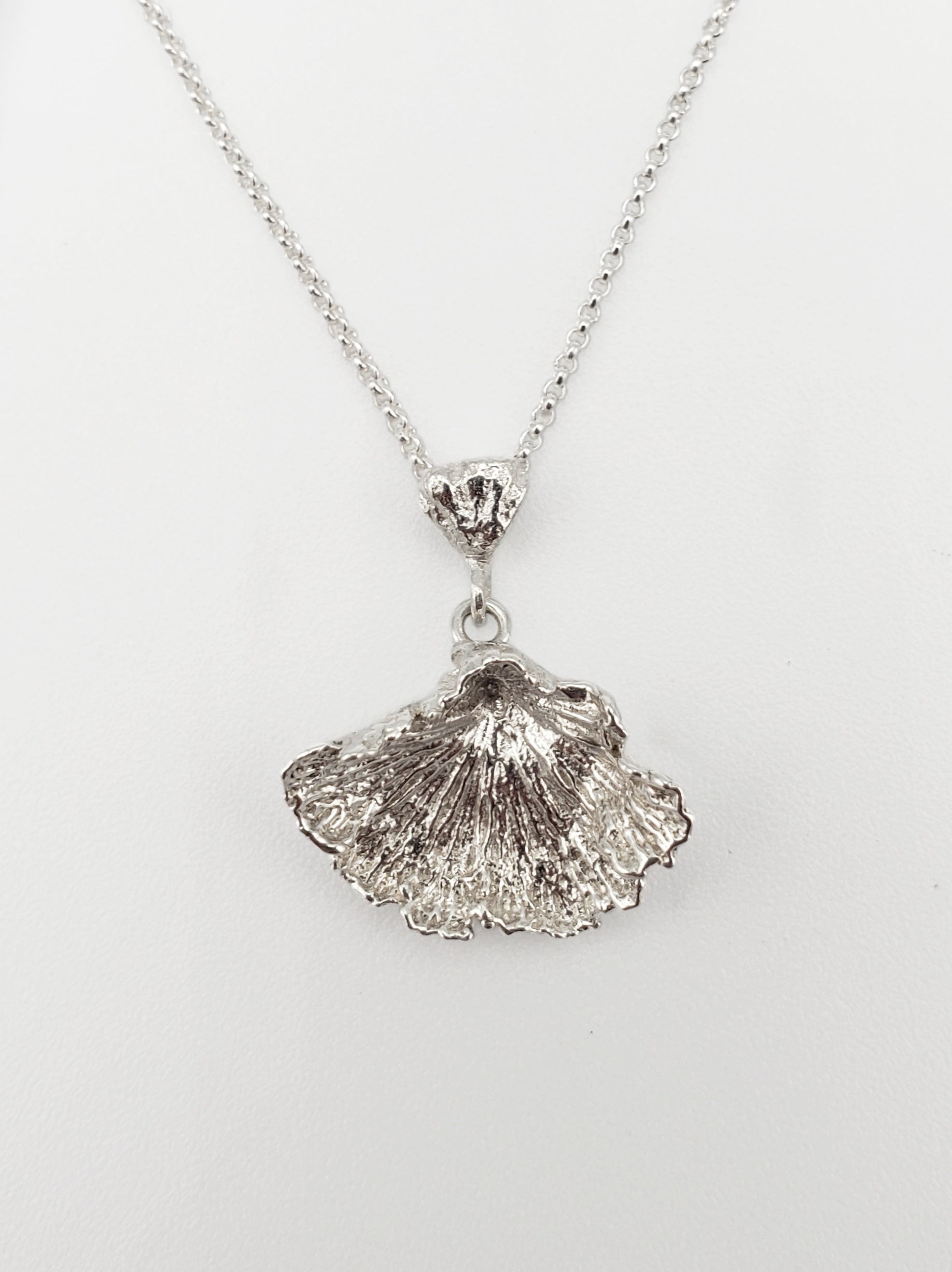 Sterling silver fungi pendant with ruffled edge.