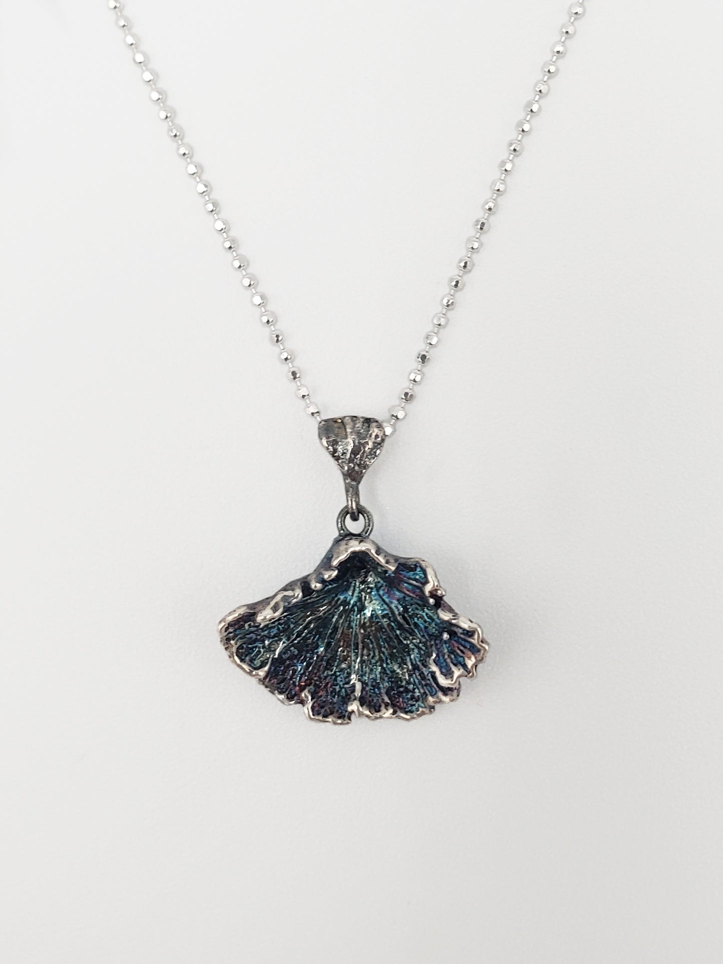 Oxidized sterling silver fungi pendant with ruffled edge.