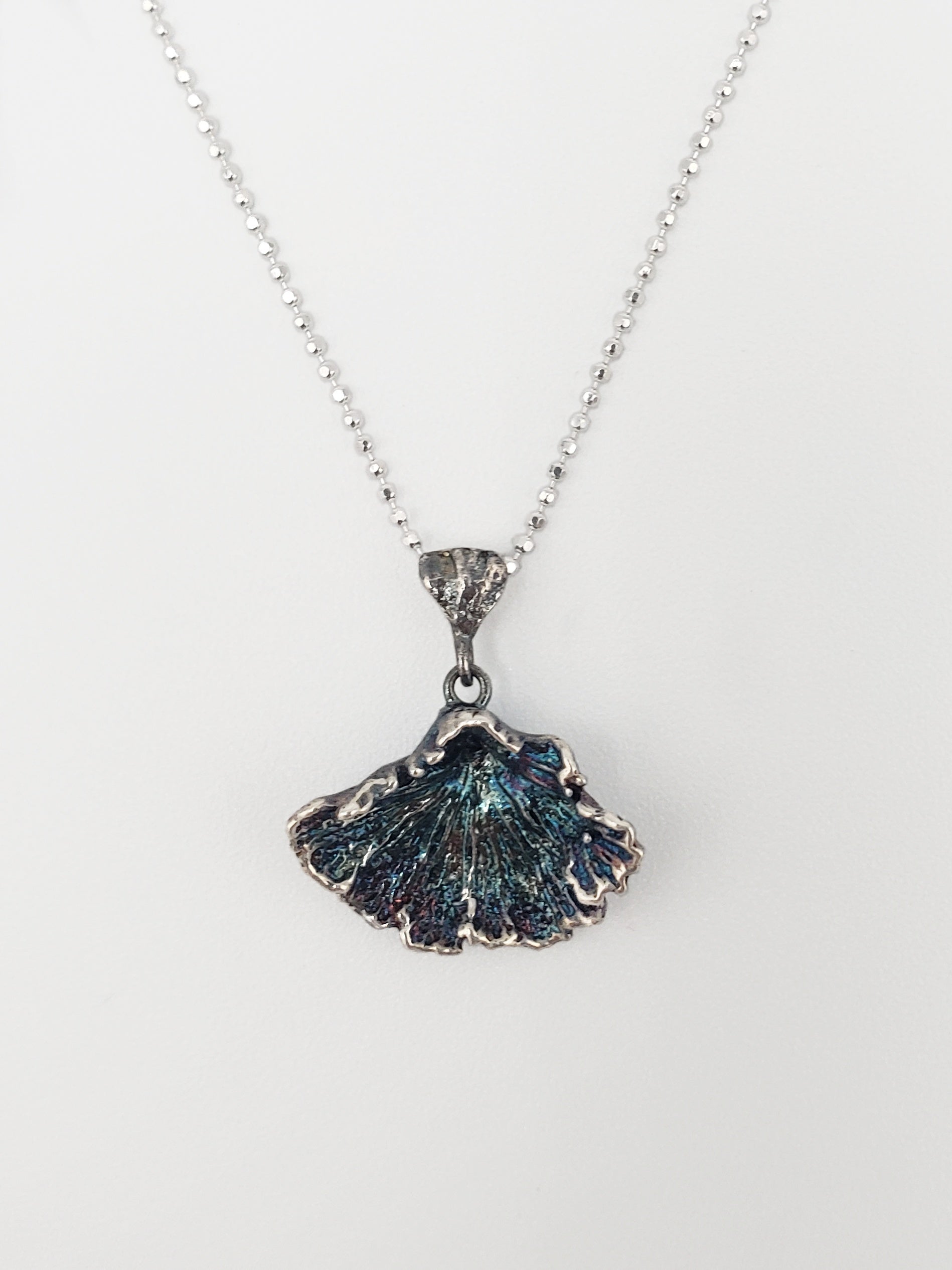 Oxidized sterling silver fungi pendant with ruffled edge.