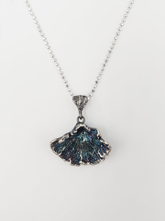 Oxidized sterling silver fungi pendant with ruffled edge.
