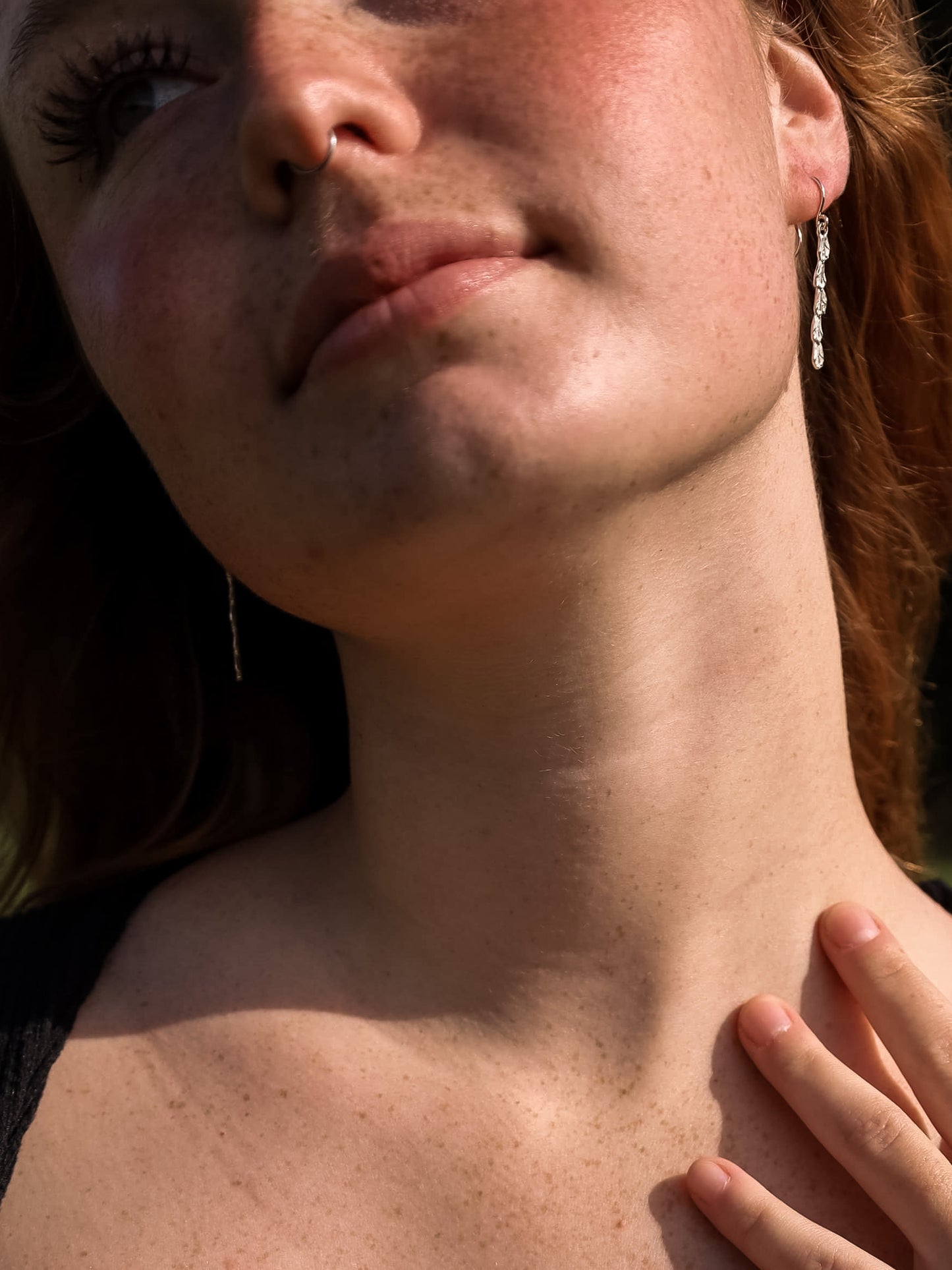 Woman wearing sterling silver cedar stick earrings.