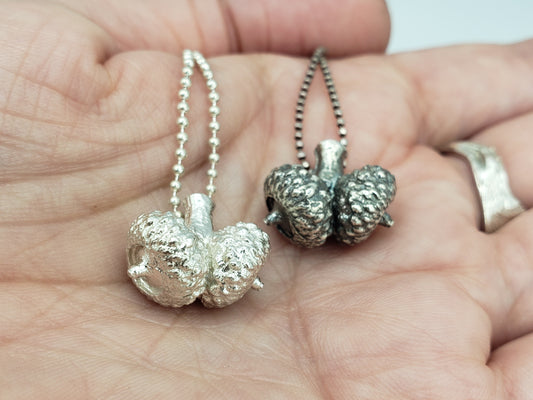 Two silver double acorn pendants. One silver colour, the other oxidized grey colour 