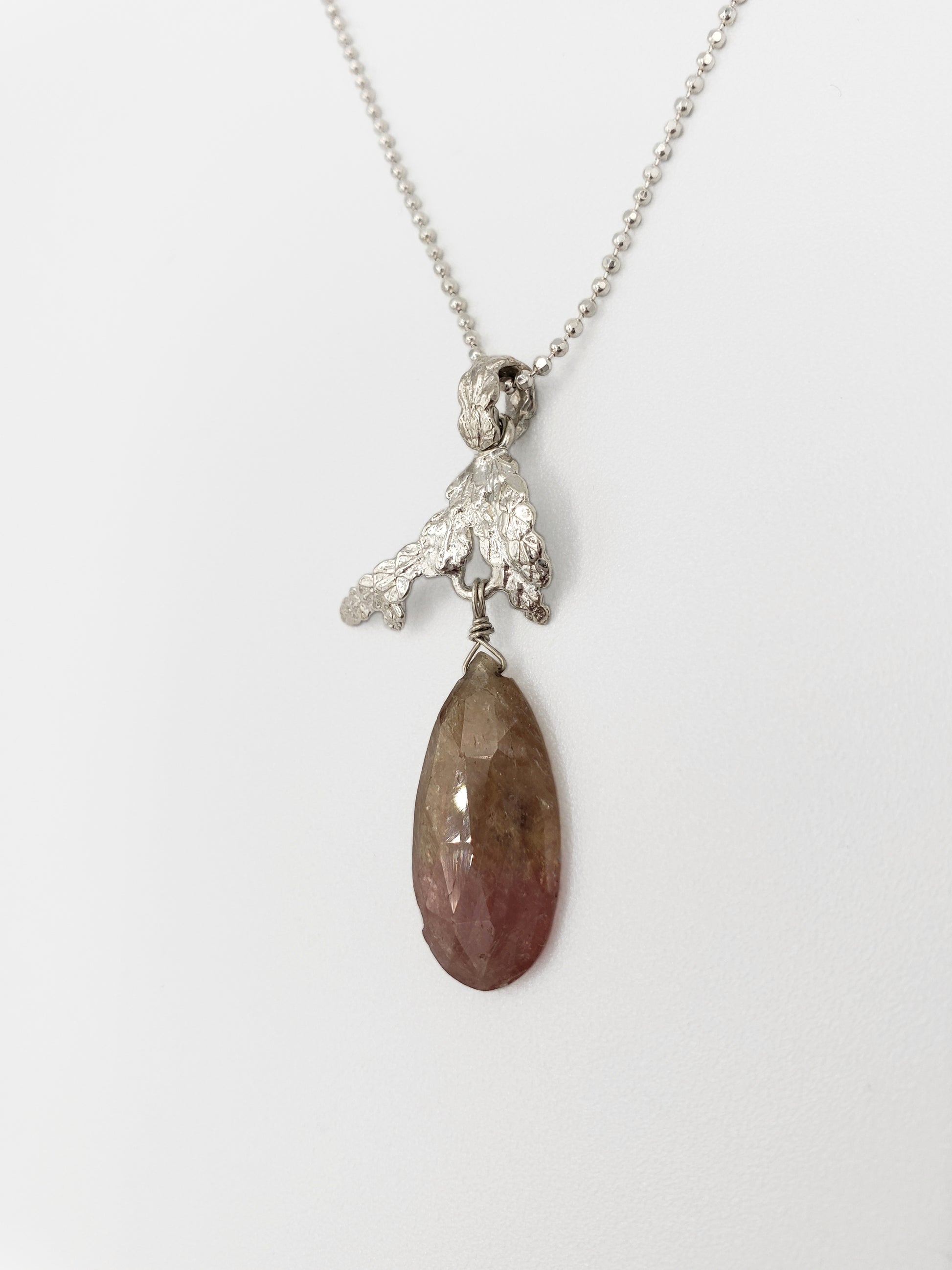 Sterling silver cedar pendant with pink and tan umba sapphire dangling from the bottom.