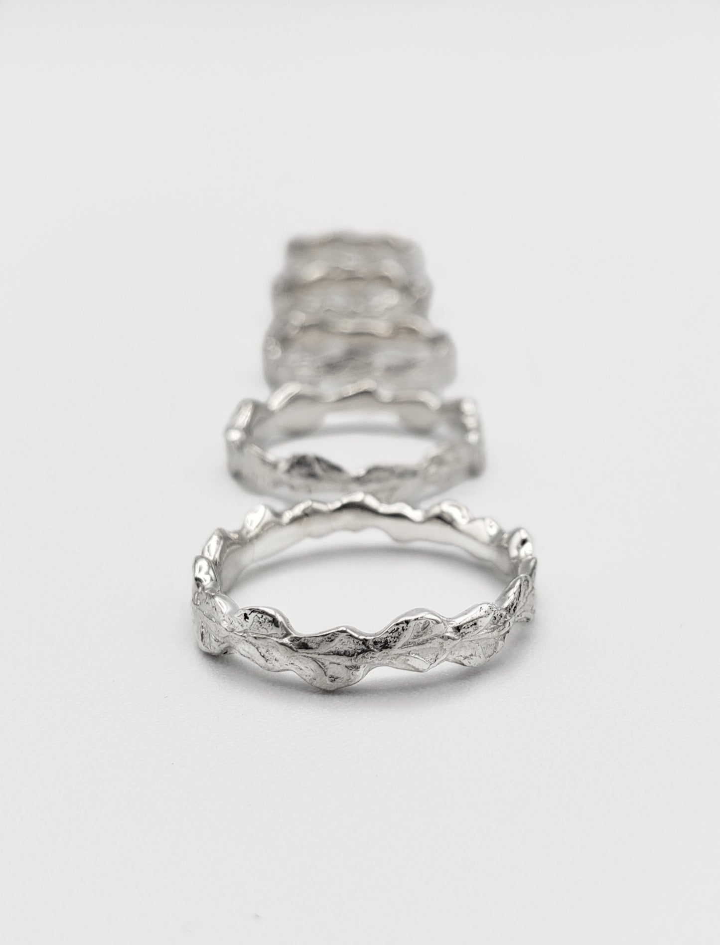 Row of five narrow sterling silver cedar rings.