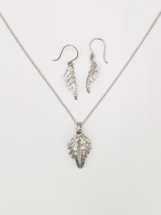 Matching set of jewellery including sterling silver cedar pendant resembling wings and small cedar dangle earrings.