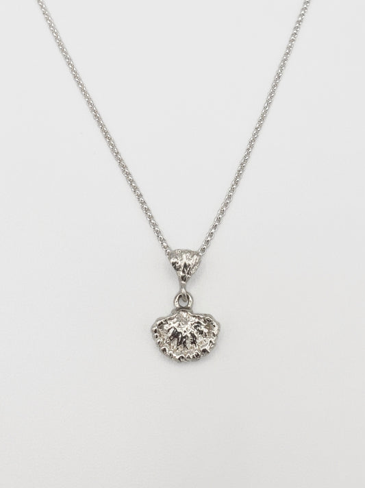 Sterling silver fungi pendant. It is positioned to show the underside of the fungi so the gills are visible.