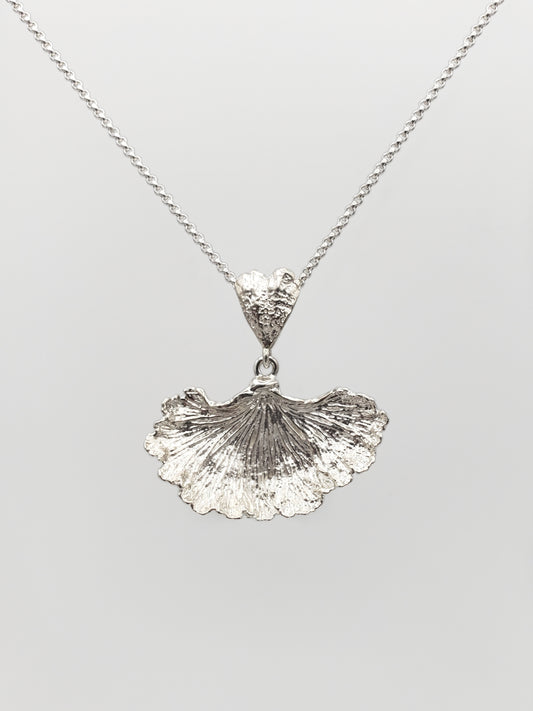 Sterling silver fungi pendant with a ruffled edge and gills showing.